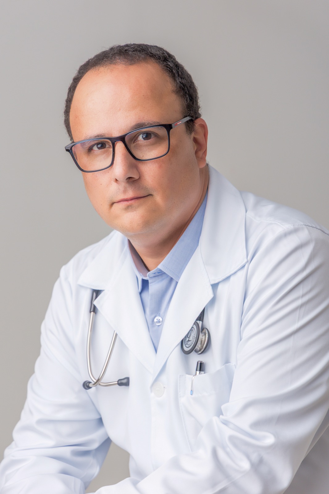 Dr. Henrique de jaleco branco com estetoscópio