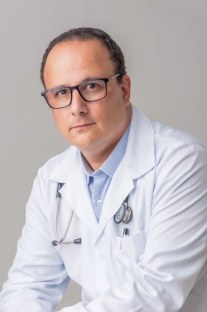 Dr. Henrique de jaleco branco com estetoscópio